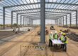 PEB steel frame erection and factory concrete flooring work at an industrial site
